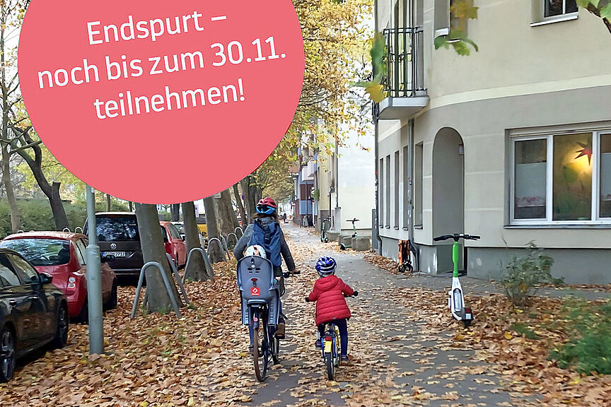Radfahren im Herbst Eine Mutter und ihre Kinder fahren auf einem herbstlich mit Blättern gesäumten Gehweg.